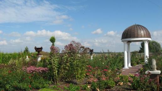 Ogród Romantyczny to ogród pełen róż. Na środku zgrabna altanka wsparta na kolumnach z piękną kopułą. , Danuta